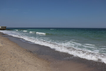 Fototapeta na wymiar Black undulating sea in Odessa on a sunny warm day.