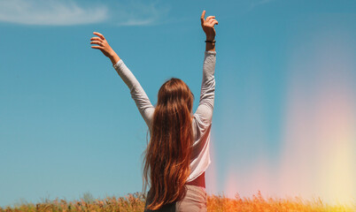 A long-haired blonde in the middle of a field with wheat raised her hands up and enjoys the air and...