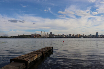 Obraz premium Wooden pier for boats on the left bank of the Dnipro city, overlooking the industrial modern right bank.