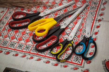 Old tailor scissors on checkered tablecloth, close-up.