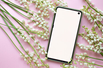 phone mockup and lily of the valley on pink table. minimalism photo