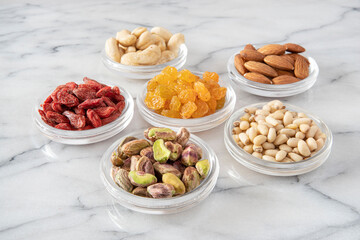 assorted dried seeds and fruit in glass saucers