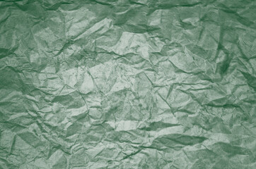 Dirty texture of old crumpled green paper. Wrinkled texture of colored packaging. St Patricks Day abstract background.