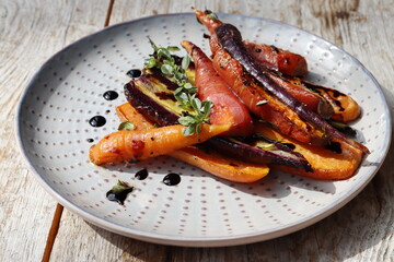 Warm salad of baked colorful carrots with balsamic cream