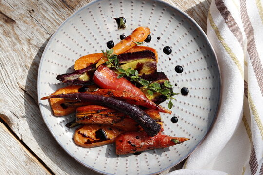 Warm salad of baked colorful carrots with balsamic cream
