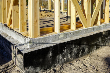 new wooden house frame concrete foundation waterproofing and damp proofing with bitumen membrane