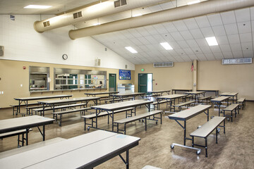 Empty school cafeteria due to COVID-19 Pandemic Shutdown. Empty tables and benches - obrazy, fototapety, plakaty