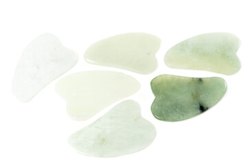 Jade guasha for spa treatments, massage stone on white background.Isolated.Chinese traditional massage - Gua Sha with stone.Jade massage scraper, gemstone .
