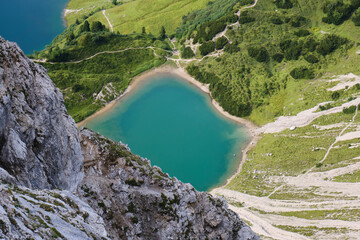 Fototapeta na wymiar View from Lachenspitze peak towards a turquoise mountain lake and hiking trails. Adventure, Summer, Austria.
