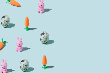 Easter pattern made with eggs, easter bunny, carrots on blue background. Creative minimal holiday concept. Flat lay, top view, copy space
