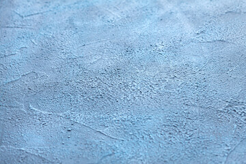 A ready-made abstract textured blue gray background with blurred edges for product and food photography. Blue textured wall. Homemade background is made with a spatula and textured putty. Copy space.