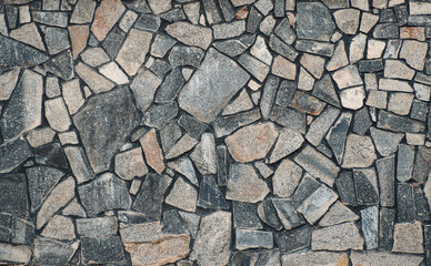 Texture of a stone. Old stone wall texture background. Grey stone wall as a background or texture. Stone wall of natural stones in different sizes. Side covering with natural stones.