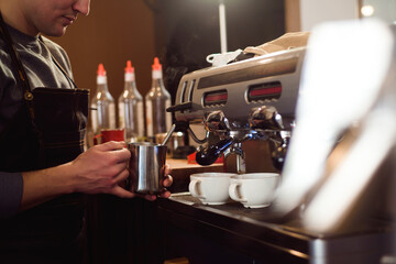 Barista making coffee using a coffee machine, hospitality and hot beverage concept.