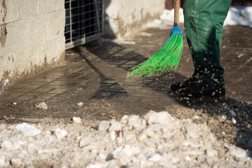 A close-up view as a worker sweeps the pavement out of loose snow