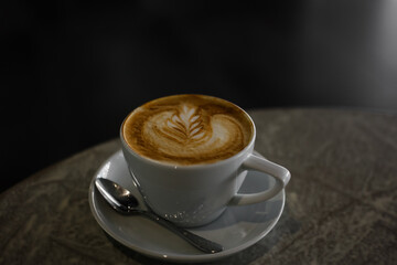 Close-up cup of coffee on the table. A mug of cappuccino with a pattern in a cup