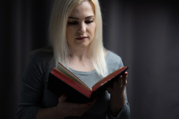 Woman place her arms on her lap and open book to read