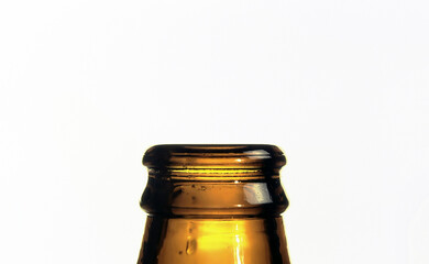 The neck of a glass beer bottle, isolated on a white background. Macro detail shot.
