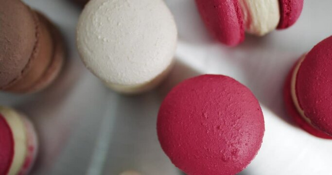 Colorful Pastel Macarons on White Background White Pink and Brown Macaron. Close up of colorful white, red, and caramel chocolate macarons dessert, on the table at light kitchen or confectionery shop
