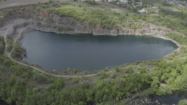 Granite quarry lake with a lot of green trees around