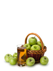 Glass with apple juice and basket with fruits of green apples