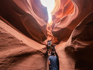 People in water shaped smooth sandstone walls to unusual curves and adges in antelope national park in arizona, america © AllThings