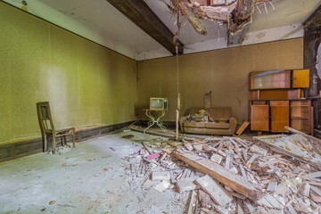 Salotto con televisore antico e soffitto crollato