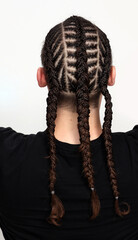 Attractive guy with braids posing in studio on isolated background. Style, trends, fashion concept.