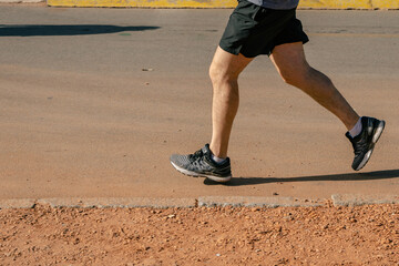 Runner feet running on road closeup on shoe. workout welness concept.