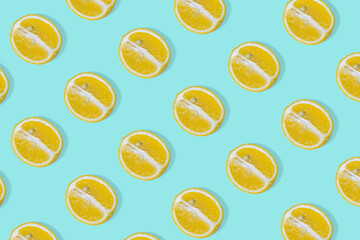 Creative summer pattern with yellow lemon slice on bright light blue background