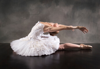 Naklejka premium Ballerina in white tutu, leaning back like a swan.