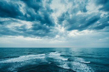 Dark blue clouds and sea or ocean water surface with foam waves before storm, dramatic seascape.