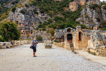 Tourist wearing medical face mask in ancient city of Myra in Demre, Antalya province in Turkey. Concept of traveling during pandemic and personal protection