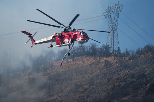 Ericsson skycrane s64 aerial firefighter helicopter dropping water on burning forest wildfire, Alpignano 16 march 2021