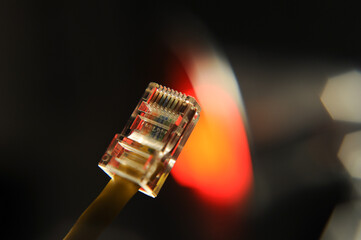 Yellow ethernet patch cable with modular connector with red and black background