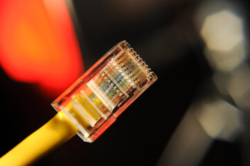 Yellow ethernet patch cable modular connector with red and black background