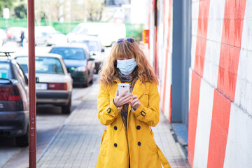 Obraz premium woman on the street with mobile phone and mask