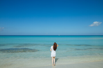 Beautiful thin woman is running along the beach. Heavenly sea in beautiful teal color. Sea in Cuba. Model on the beach 