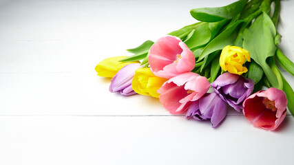 Tulip flowers on white wooden table. Colorful bouquet of spring tulip flowers