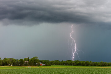 Thunderstorm and lightning strike over a field