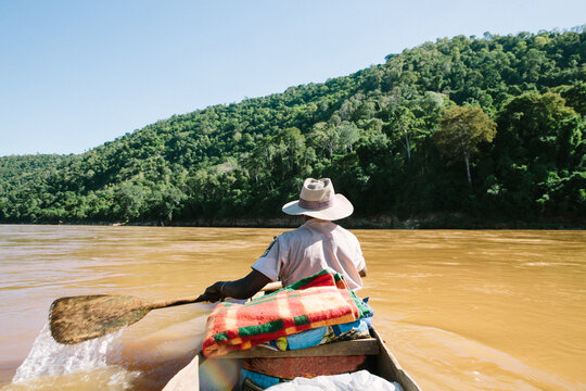Rear view of local man rowing down Tsiribihina River, Madagascar