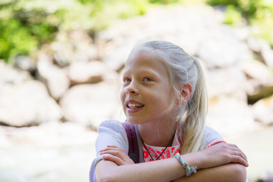 Blond haired girl with arms folded, head and shoulder portrait