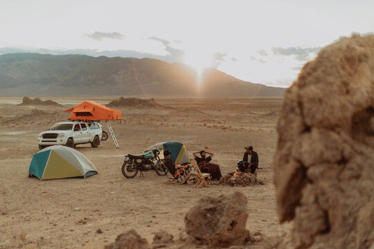Motorcyclist road trippers around camp fire, Trona Pinnacles, California, US