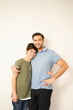 Boy and father with arms around each other, portrait