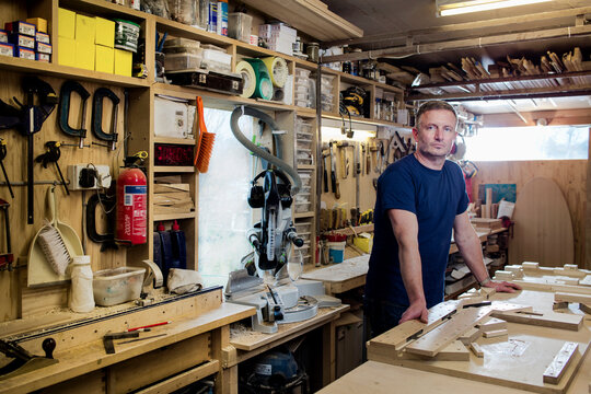 Craftsman beside his workbench and tools - Powered by Adobe