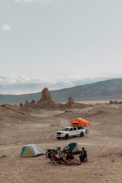 Motorcyclist road trippers around camp fire, Trona Pinnacles, California, US