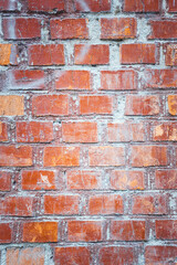 The wall, made of old red bricks, darkened by old age. Ancient vintage brick wall background. Brick wall backdrop