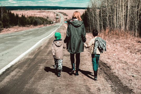 Mother and sons walking along stretch of remote road, Ural, Sverdlovsk, Russia