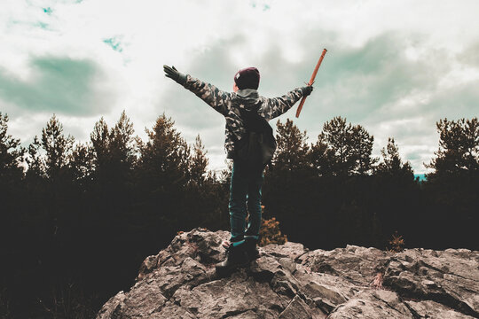 Boy on rock waving stick, Ural, Sverdlovsk, Russia