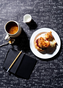 Coffee, breakfast biscuit with raspberry jam on blackboard background , overhead view