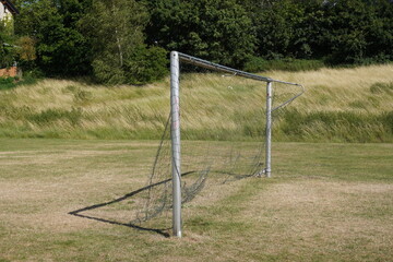 Fussballtor mit zerrissenem Netz von der Seite